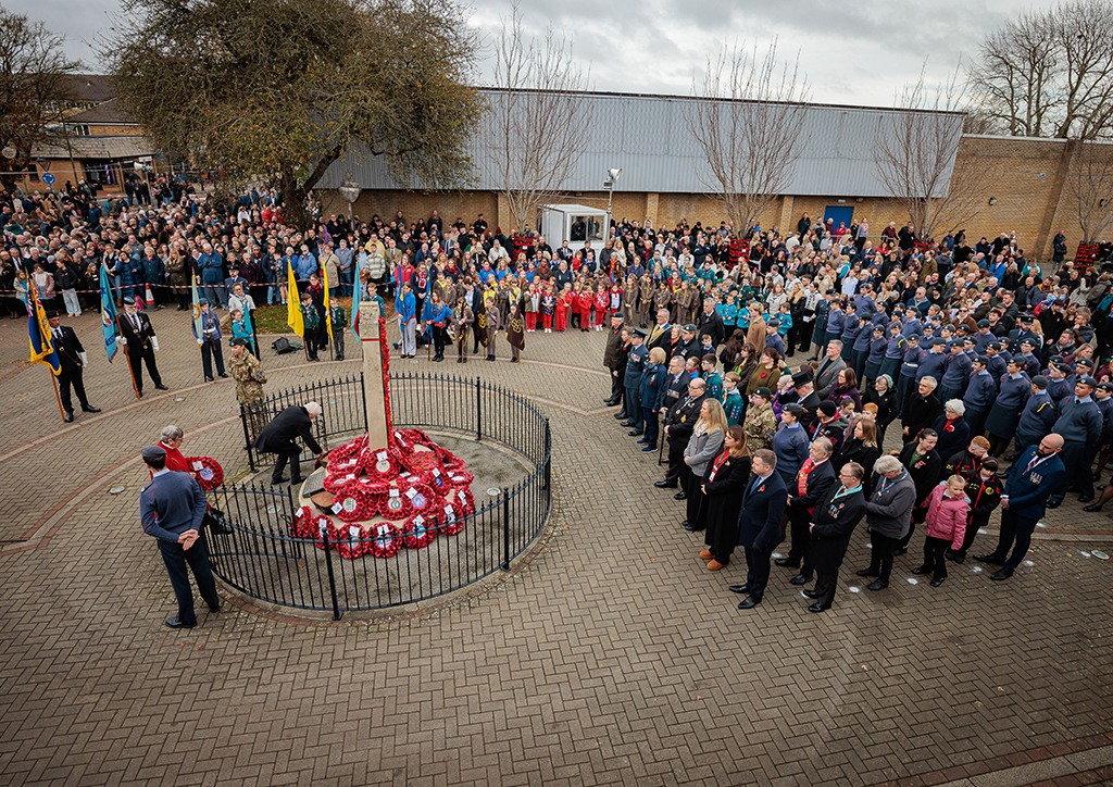 The congregation of RAF Brize Norton personnel an local residents surround the memorial, upon which, lay the wreaths of local community organisations.